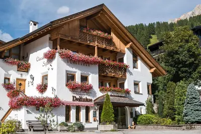 a building with flower boxes on the side of it at Ciasa Scjadu in San Cassiano