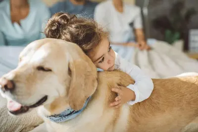 a little girl is hugging a large dog at Residence Ciasa Giardun in La Villa