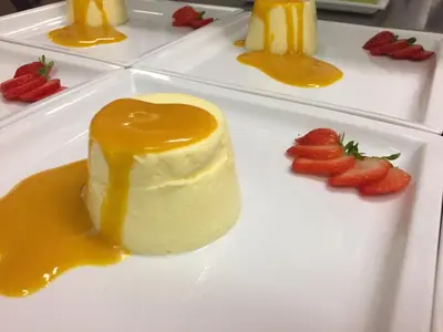 a piece of cheesecake on a plate with strawberries at Pension Mirandola in Colfosco