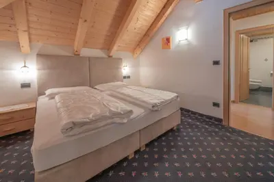 a bedroom with a large bed in a room at Residence Garni Stella in San Vigilio Di Marebbe
