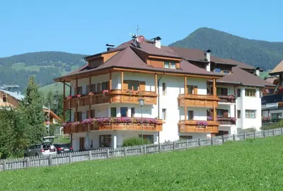 a large apartment building with balconies on a hill at Residence Garni Stella in San Vigilio Di Marebbe