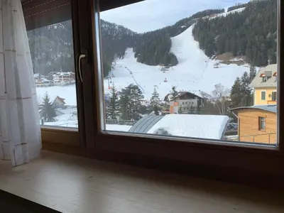 a window with a view of a snow covered mountain at Residence Garni Stella in San Vigilio Di Marebbe