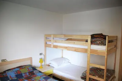 a bedroom with two bunk beds and a bed at Appartamento Col Val di Fassa con giardino BAGNI RINNOVATI 2023 in Campitello di Fassa