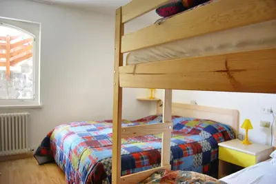 a bedroom with a bunk bed next to a bed gmaxwell gmaxwell gmaxwell at Appartamento Col Val di Fassa con giardino BAGNI RINNOVATI 2023 in Campitello di Fassa
