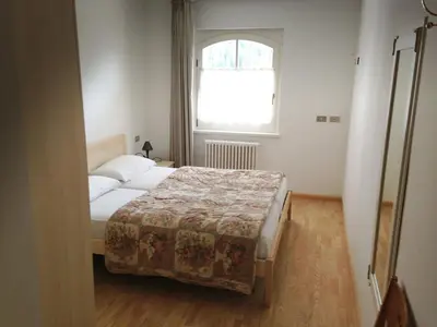 a small bedroom with a bed and a window at Appartamento Col Val di Fassa con giardino BAGNI RINNOVATI 2023 in Campitello di Fassa