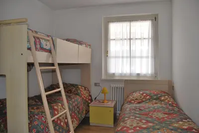 a bedroom with two bunk beds and a window at Appartamento Col Val di Fassa con Terrazza BAGNI RINNOVATI 2023 in Campitello di Fassa