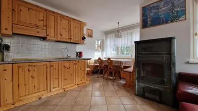 a kitchen with a fireplace and a kitchen with a table at Appartamento Col Val di Fassa con Terrazza BAGNI RINNOVATI 2023 in Campitello di Fassa