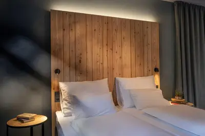 a bed with white pillows and a wooden headboard at Pension Moarhof in Campo Tures