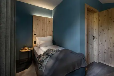 a bedroom with a bed with a blue wall at Pension Moarhof in Campo Tures