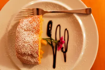 a piece of cake on a white plate with a fork at Pension Moarhof in Campo Tures