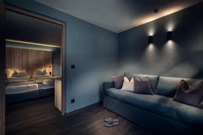 a room with a couch and a bed and a mirror at Pension Moarhof in Campo Tures