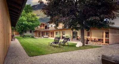 a house with a yard with chairs and a tree at Pension Moarhof in Campo Tures