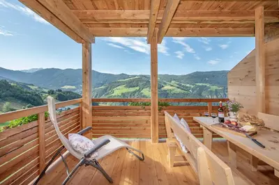 a wooden cabin with a table and chairs on a deck at Ferienbauernhof Wieserhof in Fiè