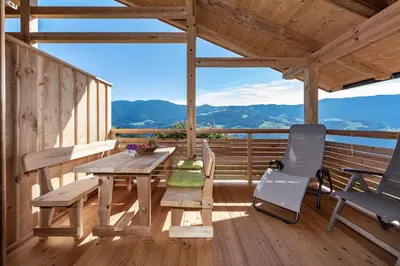 a wooden porch with a table and chairs on a deck at Ferienbauernhof Wieserhof in Fiè