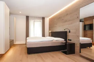 a bedroom with two beds and a large mirror at Gasthof Sonne snc in Sarntal