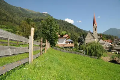 a resort with lawn chairs and a building at Chalet & Appartement Zingerlehof Trens in Campo di Trens