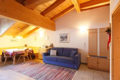 a living room with a blue couch and a table at Chalet & Appartement Zingerlehof Trens in Campo di Trens
