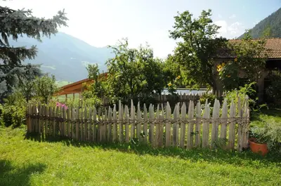 a wooden fence in the yard of a house at Chalet & Appartement Zingerlehof Trens in Campo di Trens