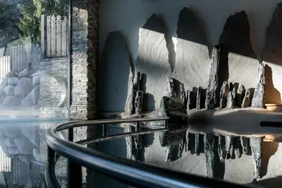 a woman standing next to a bike in front of a waterfall at Croce Bianca Leisure & Spa Hotel in Canazei