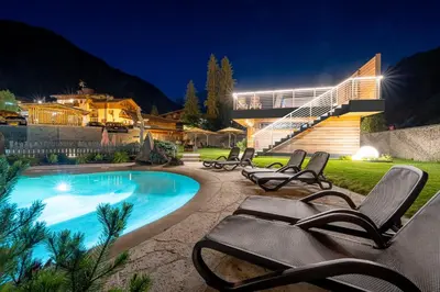 a bedroom with a bed and a desk with a monitor at Croce Bianca Leisure & Spa Hotel in Canazei