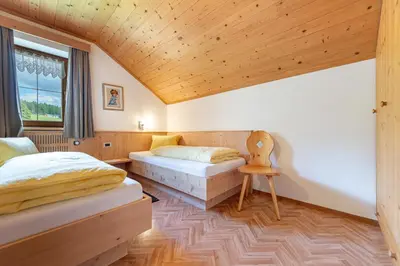 a bedroom with two beds and a wooden ceiling at Agriturismo Al Cir in San Martino in Badia