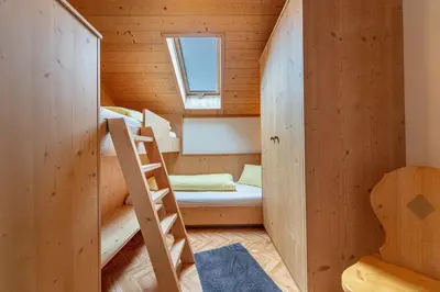 a bunk bed in a wooden room with a ladder at Agriturismo Al Cir in San Martino in Badia