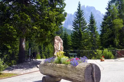 a wooden log planter with flowers in a garden at GH Hotel Fratazza in San Martino di Castrozza