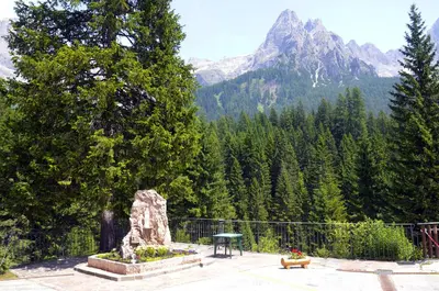 a park with a picnic table and a mountain at GH Hotel Fratazza in San Martino di Castrozza