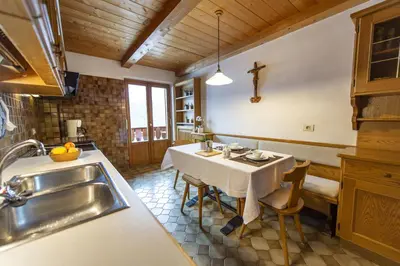 a kitchen with a table and a sink in a kitchen at Panorama Apartment Pizaut in Ortisei