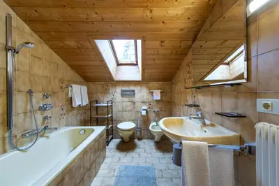 a bathroom with a tub and a sink and a toilet at Panorama Apartment Pizaut in Ortisei