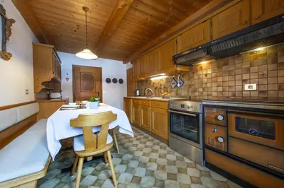 a kitchen with a table and a stove at Panorama Apartment Pizaut in Ortisei