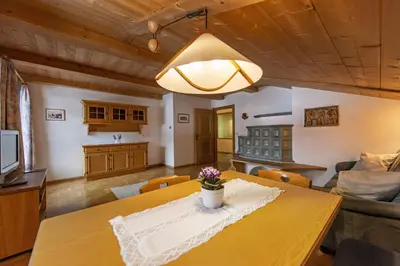 a dining room and living room with a table at Panorama Apartment Pizaut in Ortisei