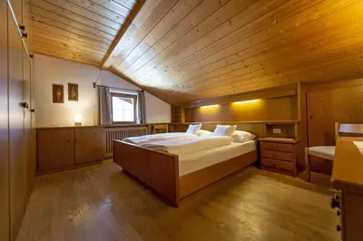 a bedroom with a large bed with a wooden ceiling at Panorama Apartment Pizaut in Ortisei