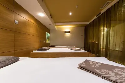 two beds in a bedroom with wooden walls at Hotel Sigmunderhof in Chienes