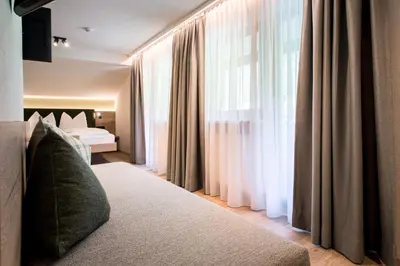 a hotel room with a bed and a window at Hotel Sigmunderhof in Chienes