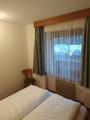 a bedroom with two beds and a window at NRH Laurin Karersee in Nova Levante