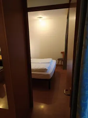 a small room with a bed and a mirror at NRH Laurin Karersee in Nova Levante