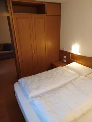 a bedroom with a large bed with a wooden headboard at NRH Laurin Karersee in Nova Levante
