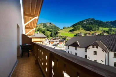 a balcony with a view of a town and mountains at HOTEL B&B MARILENA in Arabba