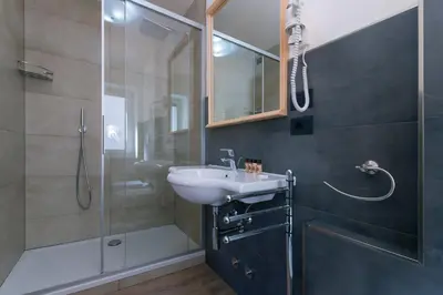 a bathroom with a sink and a shower at HOTEL B&B MARILENA in Arabba
