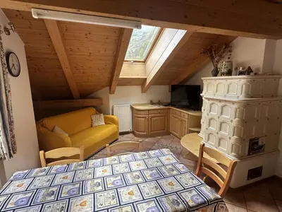 a bedroom with a bed and a couch in a room at Appartamento Star Begn - Mansarda in Soraga