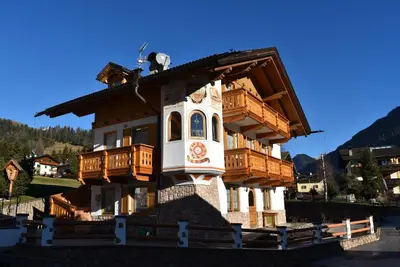 a house with a balcony on top of it at Appartamento Star Begn - Mansarda in Soraga