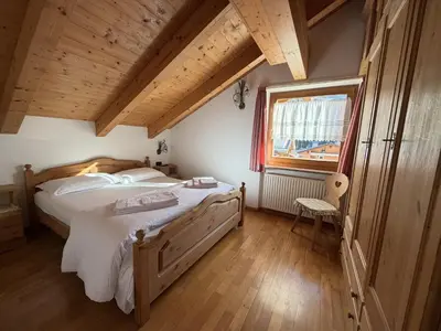 a bedroom with a large bed and a window at Appartamento Star Begn - Mansarda in Soraga