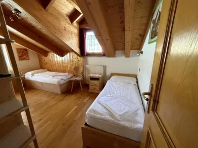 a small room with two beds in a cabin at Appartamento Star Begn - Mansarda in Soraga