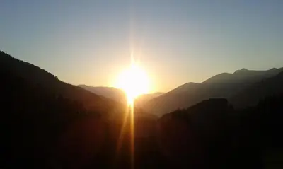 a sunset in the mountains with the sun setting at Ober-Gruberhof in Ridanna