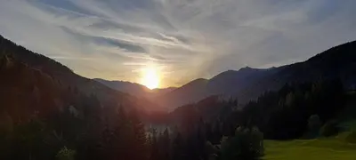 a sun setting in the middle of a mountain range at Ober-Gruberhof in Ridanna