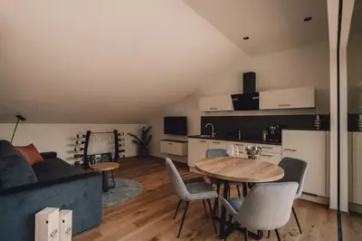 a living room with a table and a kitchen at Pitzner - Winery & Suites in Cornedo all'Isarco