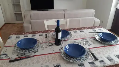 a table with blue plates and a bottle of wine at CASA MASCIA in Cencenighe