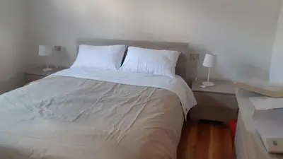 a bed with white sheets and pillows in a bedroom at CASA MASCIA in Cencenighe
