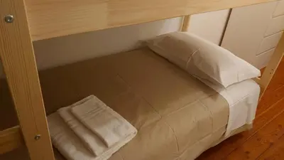 a small bed with two pillows on top of it at CASA MASCIA in Cencenighe